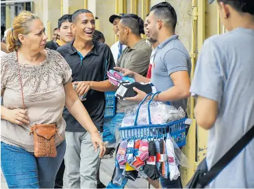  ?? FOTOS: HANSEL VÁSQUEZ ?? Luis Zambrano, con la canasta en el brazo izquierdo, vende calcetines en las calles del centro de B/quilla.