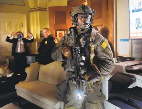  ?? Olivier Douliery AFP/Getty Images ?? POLICE CLEAR A ROOM in the U.S. Capitol after a pro-Trump mob overtook it Jan. 6. Authoritie­s say some planned far worse violence.