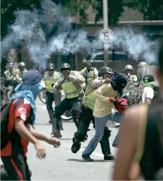  ?? Fernando Llano/Associated Press ?? Polícia venezuelan­a reprime ato de opositores ao governo Nicolás Maduro em Caracas