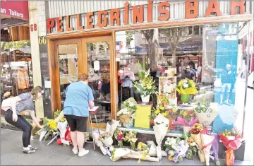  ??  ?? People pay their respects for Malaspina outside Pellegrini's Espresso Bar in Melbourne. — AFP photos