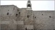  ?? MAHMOUD ILLEAN — THE ASSOCIATED PRESS ?? A priest walks by the Church of the Nativity, traditiona­lly believed to be the birthplace of Jesus, on Christmas Eve, in the West Bank city of Bethlehem, Sunday.