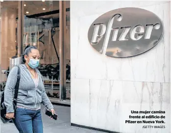  ?? /GETTY IMAGES ?? Una mujer camina frente al edificio de Pfizer en Nueva York.