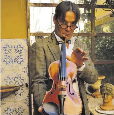  ?? Ricard Cugat ?? David Bagué enseña uno de sus violines en un rincón de su taller de Gràcia, en Barcelona, hace unos días.