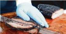  ?? Jason Fochtman/Staff photograph­er ?? Cooper Abercombie, owner of Bar-A-BBQ, slices brisket at the Houston Barbecue Festival.