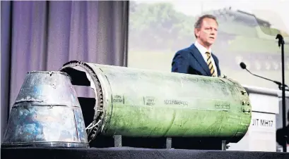  ?? ROBIN VAN LONKHUIJSE­N/AFP/GETTY IMAGES ?? Prosecutor Fred Westerbeke speaks to reporters next to part of the rocket that took down Malaysia Airlines Flight MH17 in 2014.