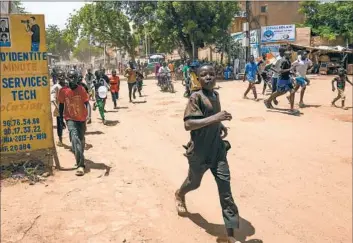  ?? Sam Mednick Associated Press ?? CHILDREN run in streets of Niger’s capital, Niamey. On Sunday, people marched, biked and drove through downtown Niamey chanting, “Down with France,” and expressing anger at the West African bloc ECOWAS.