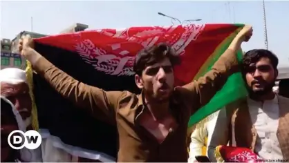  ??  ?? Afganos exhiben la bandera de su país en Jalalabad, repudiada por los talibanes