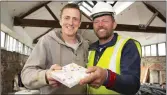  ??  ?? Tom Connick (left) with a Christenin­g present he lost at the Docks hotel 11years ago and Tom Kavanagh, project manager, who found it.