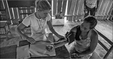  ??  ?? A doctor checks the blood pressure of a villager. (Photo: Causaopera­ria)