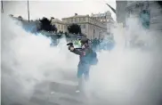  ??  ?? POOR VISIBILITY: A cameraman films through a cloud of teargas in Paris on Saturday during the anti-government demonstrat­ion by the ‘yellow-vest’ movement