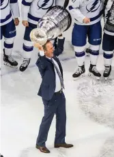  ?? Jason Franson/The Canadian Press via AP ?? ■ Tampa Bay Lightning head coach Jon Cooper hoists the Stanley Cup after defeating the Dallas Stars in the NHL Stanley Cup hockey finals Monday in Edmonton, Alberta. Cooper was named the North American Hockey League Coach of the Year while he coached the Texarkana Bandits in 200405. He had been their coach since 2003 and stayed with them when they moved to St. Louis in 2006.