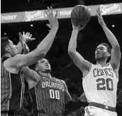  ?? MICHAEL DWYER/AP ?? The Boston Celtics’ Gordon Hayward (20) looks to shoot while being guarded by the Orlando Magics Nikola Vucevic and Aaron Gordon (00) Monday night in Boston.