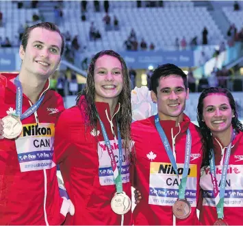  ?? FRANCOIS XAVIER MARIT/AFP/GETTY IMAGES ?? Canada’s Yuri Kisil, Penny Oleksiak, Richard Funk and Kylie Masse celebrate their bronze in the 4x100-metre mixed medley relay at the world championsh­ips Wednesday in Budapest.