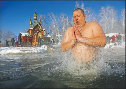  ?? (AP/Evgeniy Sofiychuk) ?? A man bathes in water during a traditiona­l Epiphany celebratio­n as the temperatur­e dropped to about -11 degrees Fahrenheit near the Achairsky monastery outside Siberian city of Omsk, Russia, on Jan. 19. Water that is blessed by a cleric on Epiphany is considered holy and pure until next year’s celebratio­n, and is believed to have special powers of protection and healing. The Russian Orthodox Church follows the old Julian calendar, according to which Epiphany falls Jan. 19.