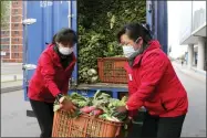  ?? AP PHOTO/JON CHOL JIN ?? Employees of a greengroce­ry in Mirae Scientists Street carry cabbages to supply to residents staying home as the state increased measures to stop the spread of illness in Pyongyang, North Korea Monday, May 16, 2022.