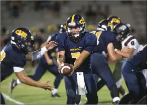  ??  ?? Calipatria High School's senior quarterbac­k Julian Medina hands the ball off to senior running back Nate Banuelos during their home game against Classical Academy High School on Friday night at Veteran's Field in Calipatria. VINCENT OSUNA PHOTO