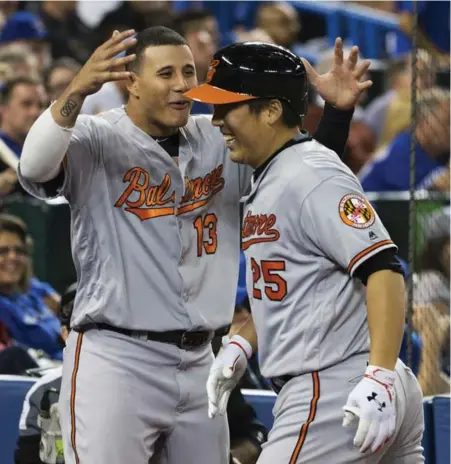  ?? MELISSA RENWICK/TORONTO STAR ?? The Orioles’ Hyun Soo Kim is greeted at home plate after hitting a two-run shot off Roberto Osuna in the ninth inning on Wednesday night.