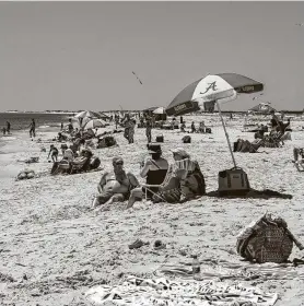  ?? Maranie Staab / Bloomberg ?? People sit on the sand at a public beach in Dauphin Island, Ala., on Friday. Alabama allowed most businesses to open, subject to certain guidelines.