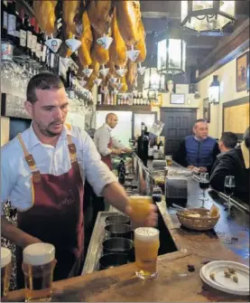  ?? / PACO PUENTES ?? Un camarero sirve cerveza en un bar de Sevilla.