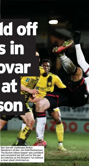  ?? ?? Ben Garratt challenges Bolton Wanderers striker Jon Dadi Bodvarsson. The Burton Albion keeper was confident and consistent but left out for the last six matches as the Brewers’ run without a clean sheet stretched on.