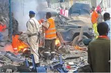  ?? AP-Yonhap ?? Somali soldiers inspect wreckage of vehicles after a suicide car bomber detonated a vehicle in Mogadishu, Saturday.