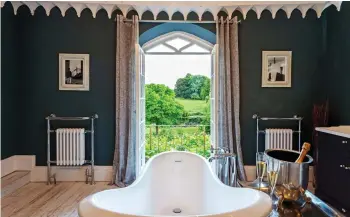  ??  ?? GOTHIC SPLENDOUR: Thornemead Castle in Somerset, top left. Top: The living area at Bodney Lodge in Norfolk.
Above: The view from the slipper bath at Colleton Hall, Devon