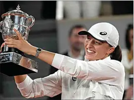  ?? CHRISTOPHE ENA / AP ?? Poland’s Iga Swiatek presents the cup after defeating Coco Gauff of the U.S. in the women’s final match of the French Open tennis tournament at the Roland Garros stadium Saturday in Paris. Swiatek won 6-1, 6-3.