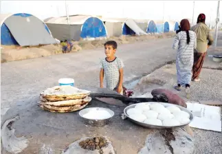  ??  ?? Displaced Iraqi family from Mosul bakes bread for their iftar, during the holy month of Ramadan at a refugee camp Al-Khazir in the outskirts of Erbil, on Saturday. (Reuters)