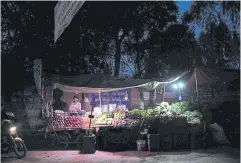  ?? BLOOMBERG ?? Vendors sell fruit under lights lit by batteries in Lahore, Pakistan on Monday.