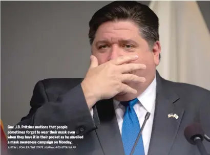  ??  ?? JUSTIN L. FOWLER/THE STATE JOURNAL-REGISTER VIA AP Gov. J.B. Pritzker motions that people sometimes forget to wear their mask even when they have it in their pocket as he unveiled a mask awareness campaign on Monday.