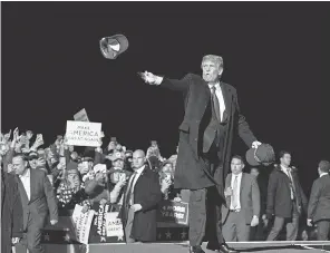  ?? ALEX BRANDON/ AP ?? President Donald Trump tosses a hat to supporters as he arrives at a rally at Duluth Internatio­nal Airport on Wednesday in Minnesota.
