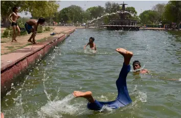  ?? — AFP ?? Children take a dip in the shallow pool along the India Gate as the city reeled under heatwave on Sunday.