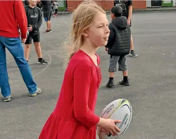  ?? PHOTO:ELEANOR WENMAN/FAIRFAX NZ ?? Konini Primary School student Isla Adrian does her part to make 18,804 rugby passes to celebrate the Lions tour.