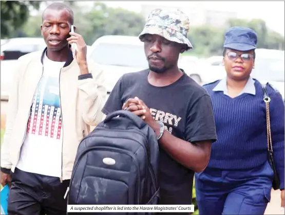  ?? ?? A suspected shoplifter is led into the Harare Magistrate­s’ Courts