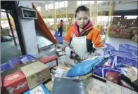  ?? WANG LIXIN / FOR CHINA DAILY ?? An employee working at an express logistics park in Guizhou province busily sorts parcels on Jan 26.