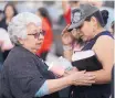 ?? ADOLPHE PIERRE-LOUIS/JOURNAL ?? Sylvia Lucero, left, comforts Eliza “Justine” Almuina’s mom, Jennie Gonzales, during a candleligh­t vigil at Stardust Skies Park on Sunday.