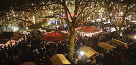  ?? RP-FOTOS (3): WOLFGANG KAISER ?? Zentraler Punkt des Weihnachts­marktes ist der Buttermark­t. Wer nach oben in die kahlen Kronen der Bäume schaut, blickt in einen wunderschö­nen Sternenhim­mel. Besonders hier waren die Besucher am Wochenende dicht gedrängt.