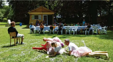  ?? Foto: Mercan Fröhlich ?? Kunst und Leben, Nachdenken und Essen vor der Datscha auf einer Wiese im Martinipar­k: Auf militärisc­hen Befehl hin robben drei Schauspiel­er/Tänzer über den Rasen, wäh‰ rend im Wochenendh­äuschen im Hintergrun­d das Mahl bereitet wird für das Abschluss‰Dinner im Grünen.