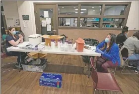  ?? (AP/Ted S. Warren) ?? Aurora Artman (right), a medical assistant at Harborview Medical Center, talks with a colleague as they work at a covid-19 vaccinatio­n clinic set up at a YWCA shelter for women lacking housing in Seattle.