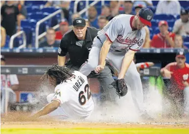  ?? DAVID SANTIAGO/TNS ?? Marlins pinch runner Jose Urena scores the tying run after a wild pitch as Washington Nationals pitcher Max Scherzer tries to apply the tag in time during the eighth inning Wednesday.