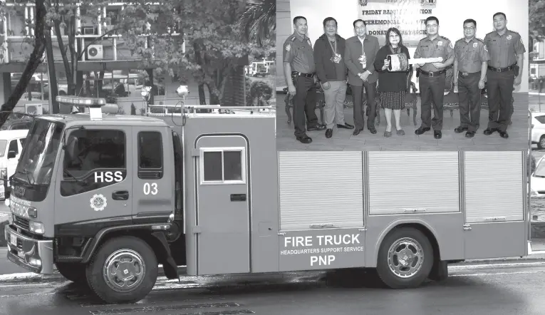  ?? (PNA photo by Gil Calinga) ?? FIRE TRUCK. Ma. Alegria Sibal Limjoco, (center, inset photo), president of the Philippine Chamber of Commerce and Industry (PCCI), turns over the symbolic key to BGen Dennis L. Basngi (3rd from right), Director, Headquarte­rs Support Service of the Philippine National Polie (PNP), for an Isuzu Fire Truck to be used at the Base Fire Section, Headquarte­rs Support Service in Camp Crame, Quezon City on Friday (August 2, 2019). Also in photo are Philexport president and PCCI Honorary Chairman and Treasurer Sergio Ortiz-Luis Jr. (3rd from left); PCCI-Director Renato Simbulan (2nd from left); and other PNP officials.