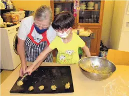  ?? ?? COURTESY OF NEW MEXICO SCHOOL FOR THE BLIND AND VISUALLY IMPAIRED Mandy Blaes, right, scoops cookie dough from a bowl for a cooking lesson with help from Life Skills Assistant Julie Guthart at the New Mexico School for the Blind and Visually Impaired in 2022.