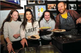  ??  ?? Pobalscoil Chorca Dhuibhne third year students Ailisa Finn-Ní Shé, Sinéad O’Connor and Alanna Hand feeding the walkers in Páidí Ó Sé’s - with a little help from Ed Mulvihill of the Grey’s Lane Bistro.