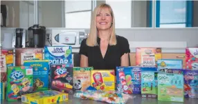  ?? CITIZEN NEWS SERVICE PHOTO BY DEBBY HEROLD ?? Charlene Elliott, of the University of Calgary, poses with an array of glutenfree packaged foods marketed for children in an undated photo.