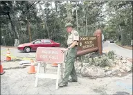  ??  ?? Point Lobos State Natural Reserve aide Jim Nolte posts a “parking lot full” sign at 11 a.m. Saturday.