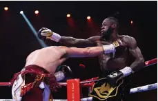  ?? Getty Images ?? Anthony Johsua, top, celebrates after his victory over Otto Wallin in Saudi Arabia. Above, Deontay Wilders swings and misses during his loss to Joseph Parker