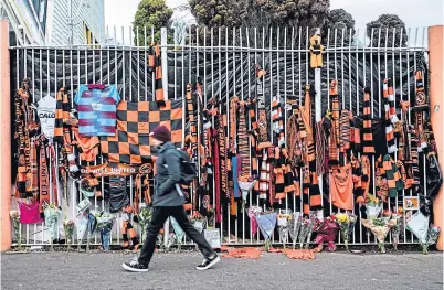  ??  ?? A sea of scarves and football tops adorn the gates at Tannadice following Jim McLean’s death.