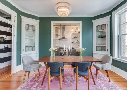  ?? Photos byGoran Kosanovic/The Washington Post ?? Above, the dining room in Louisa Bargeron’s apartment in Washington, D.C., retains two original corner cabinets with leaded glass. The walls were painted a warm green (Lafayette Green by Benjamin Moore). Below, wide black-and-white painted stripes add...