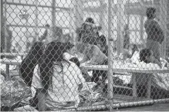  ?? HANDOUT / AFP/Getty Images ?? In this photo provided by U.S. Customs and Border Protection people who illegally entered the United States sit at the central processing center in McAllen.
