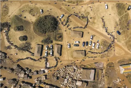  ?? Bram Janssen / Associated Press ?? An aerial view shows people waiting in lines to cast their ballots at an election polling station in the capital of Harare.